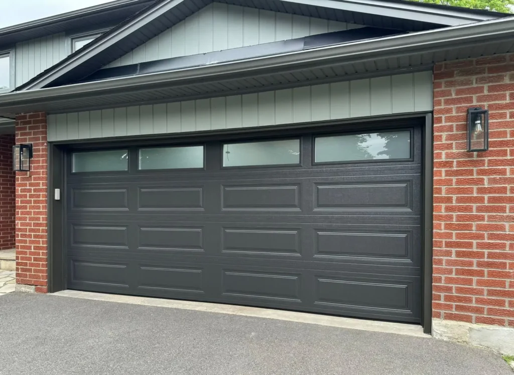 Long-panel-garage-door-in-charcoal-grays-with-top-frosted-windows.webp